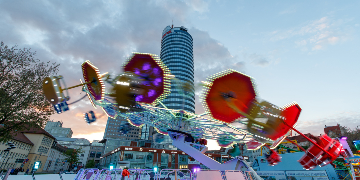 Beleuchteter Twister auf dem Rummel des Jenaer Frühlingsmarktes mit Jentower im Hintergrund