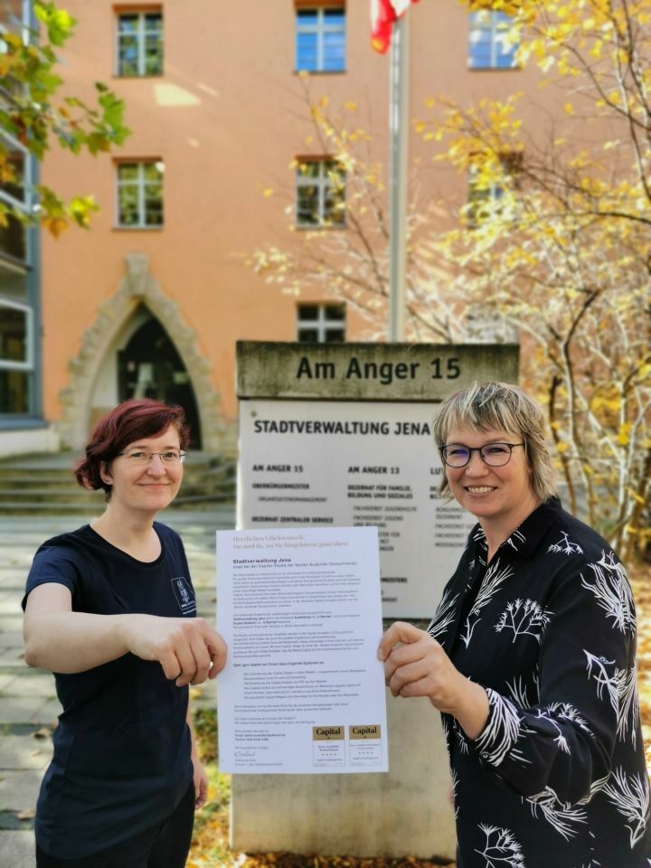 Anja Andritzke und Antonia Erdmann vor dem Rathaus Jena mit der Auszeichnung als eine der besten Ausbildungsstätten