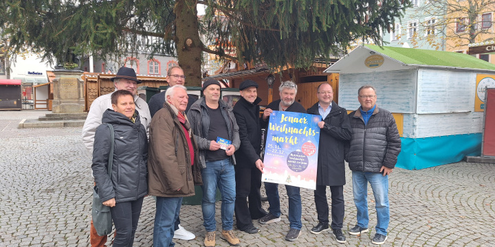 Die Organisatoren des Jenaer Weihnachtsmarktes halten das Plakat des Jenaer Weihnachtsmarktes hoch.  ©JenaKultur