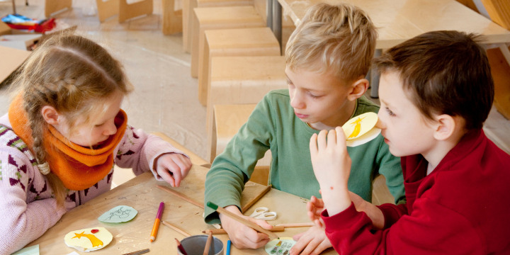 Drei Kinder basteln mit Papier