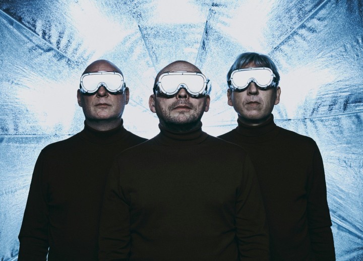 Bandmitglieder von Rymden mit reflektierenden Schutzbrillen vor einem metallic-blauen Schirm
