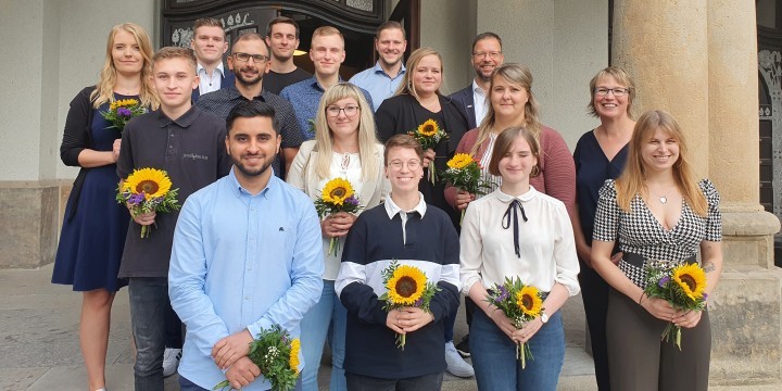 Ausbildungsabsolventen bei der Stadt Jena 2022 mit Blumensträußen vor dem Volksbad Jena  ©Stadt Jena