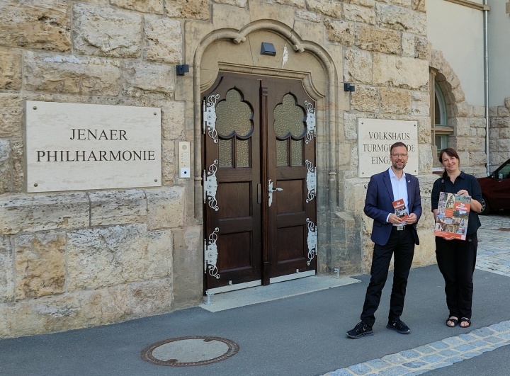 Oberbürgermeister Thomas Nitzsche und Elke Zimmermann vor dem Volkshaus Jena mit Plakaten und Flyern zum Tag des offenen Denkmals 2024