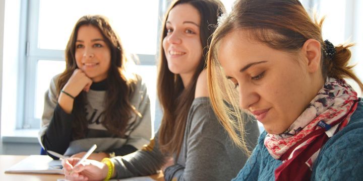 Junge Frauen sitzen an einem Tisch und lernen