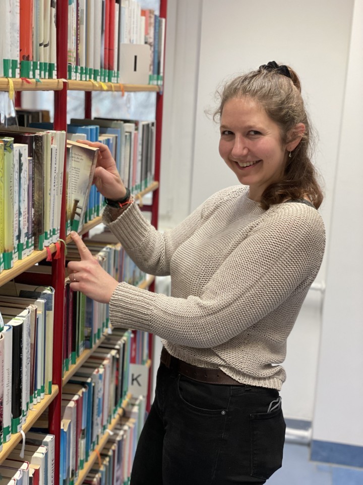 Fachangestellte für Medien- und Informationsdienste Wiebke John an ihrem Arbeitsplatz, einem Bücherregal in der Ernst-Abbe-Bücherei Jena